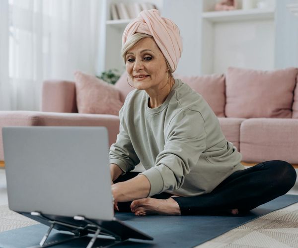 Laptop screen showing an online yoga class with multiple participants.